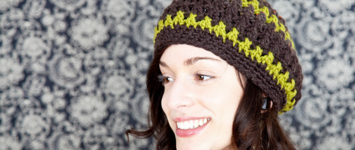 stock photo of a young woman wearing a handmade beret style hat; smiling