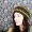 stock photo of a young woman wearing a handmade beret style hat; smiling